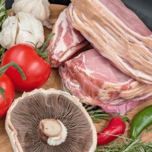 Selection of smoked back bacon with various vegetables and herbs